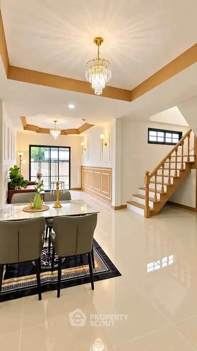 Elegant living room with modern chandelier and staircase in luxury home