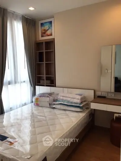 Cozy bedroom with natural light, modern furnishings, and ample storage space.