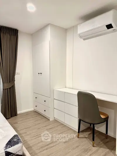 Modern bedroom with built-in wardrobe and study desk, featuring sleek design and air conditioning.