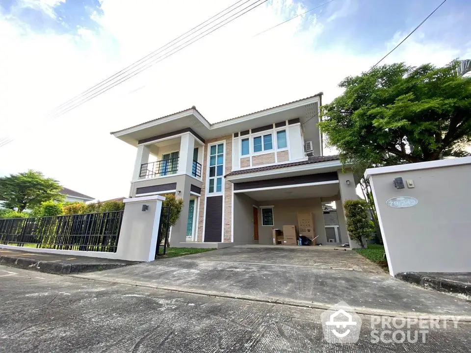 Modern two-story house with spacious driveway and lush greenery