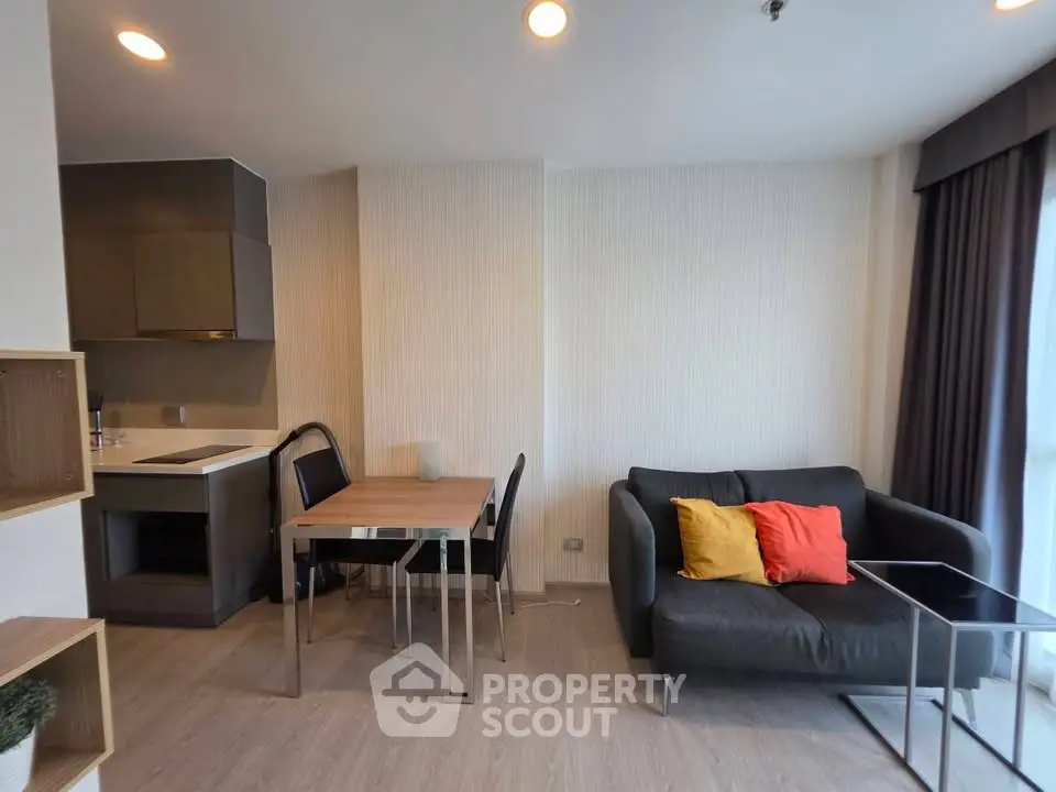 Modern living room with open kitchen, cozy sofa, and dining area in a stylish apartment.