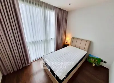 Cozy bedroom with elegant curtains and soft lighting, perfect for relaxation.
