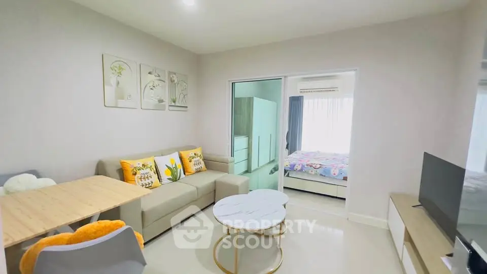 Modern living room with cozy decor and open view to bedroom