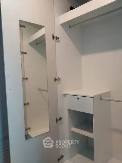 Spacious walk-in closet with ample shelving and mirror in modern home.