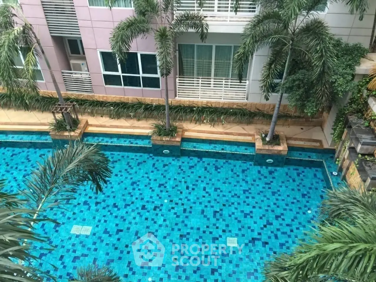 Luxurious apartment complex with a stunning swimming pool and lush palm trees, perfect for relaxation and leisure.