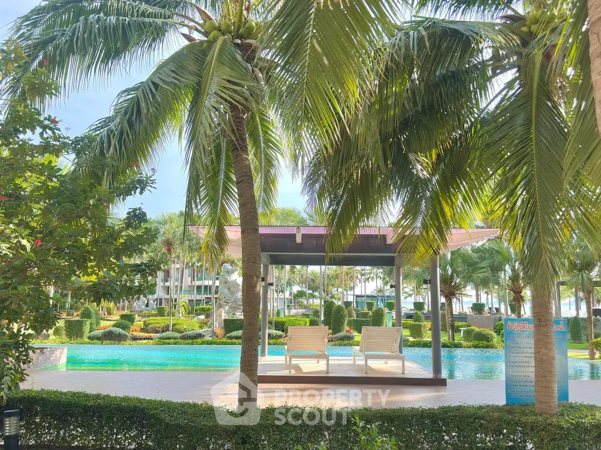 Luxurious poolside view with lush greenery and palm trees, perfect for relaxation and leisure.