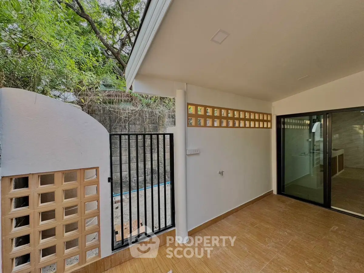 Charming outdoor patio with modern design and lush greenery, perfect for relaxation and entertaining.