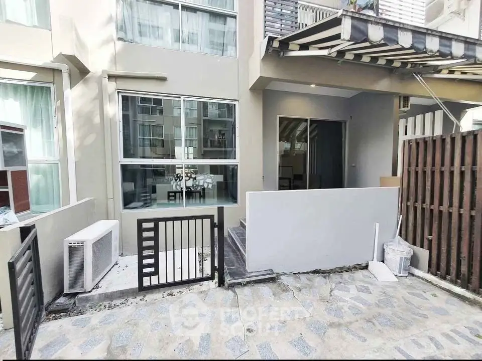Modern townhouse exterior with patio and large windows