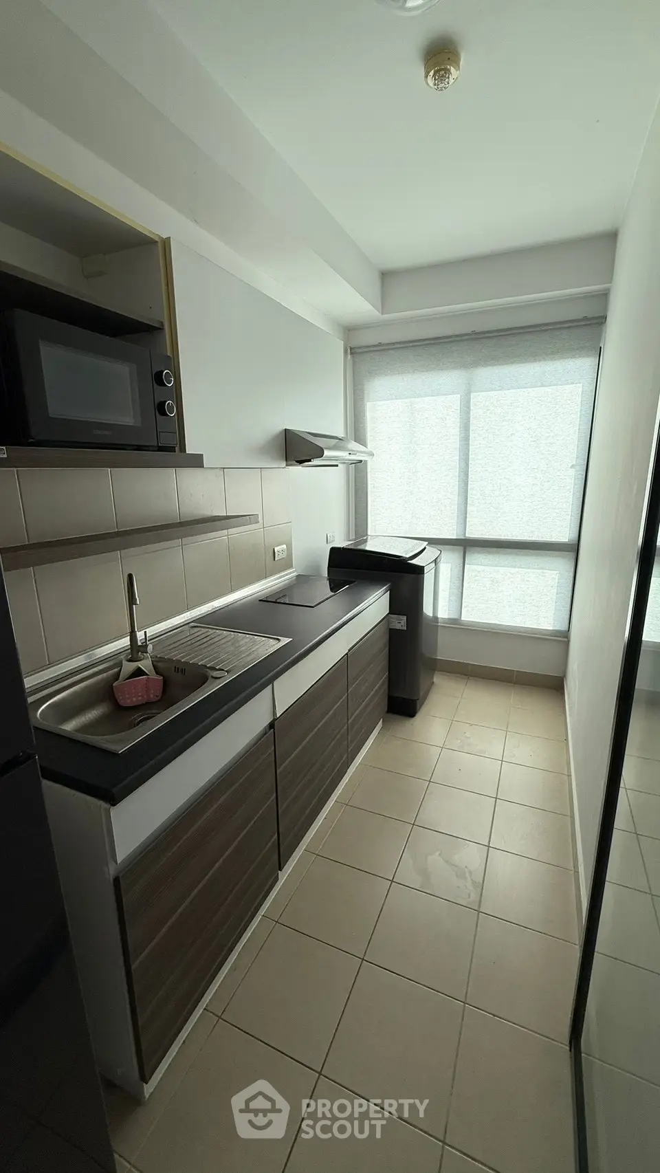 Modern kitchen with sleek cabinetry and large window for natural light.