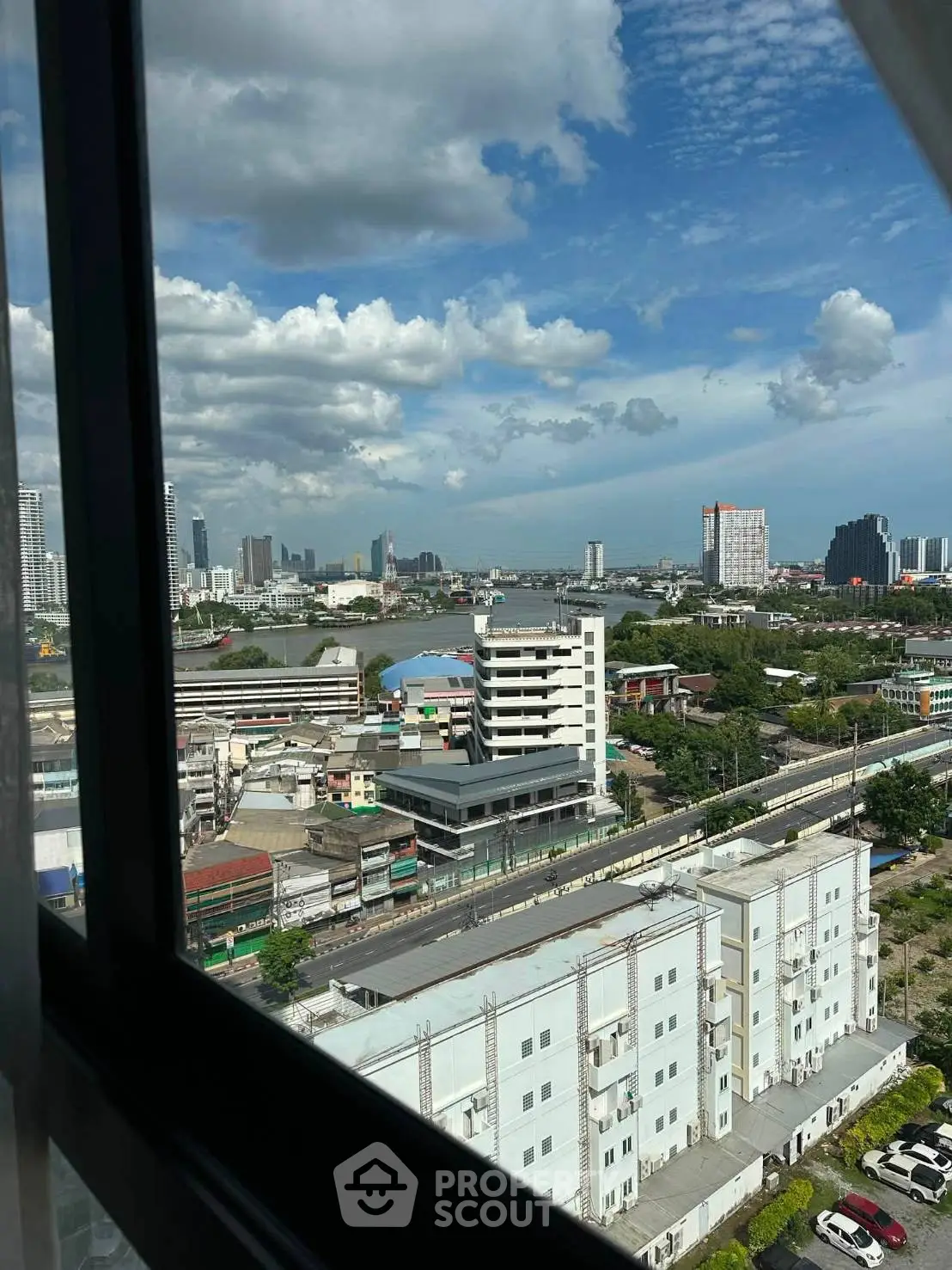 Stunning cityscape view from high-rise window overlooking urban skyline and river.