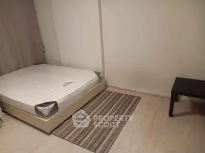 Minimalist bedroom with bed and small table on wooden floor