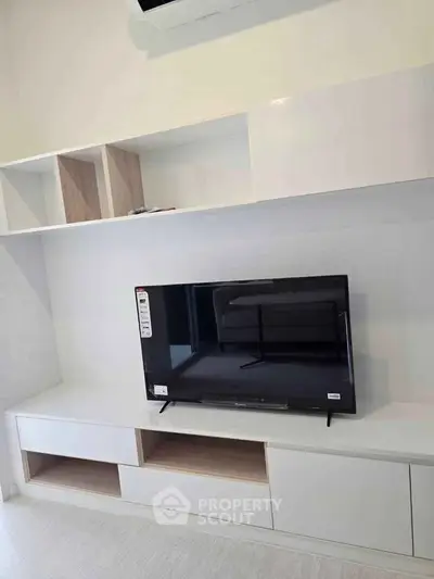 Modern living room with sleek TV unit and built-in storage shelves