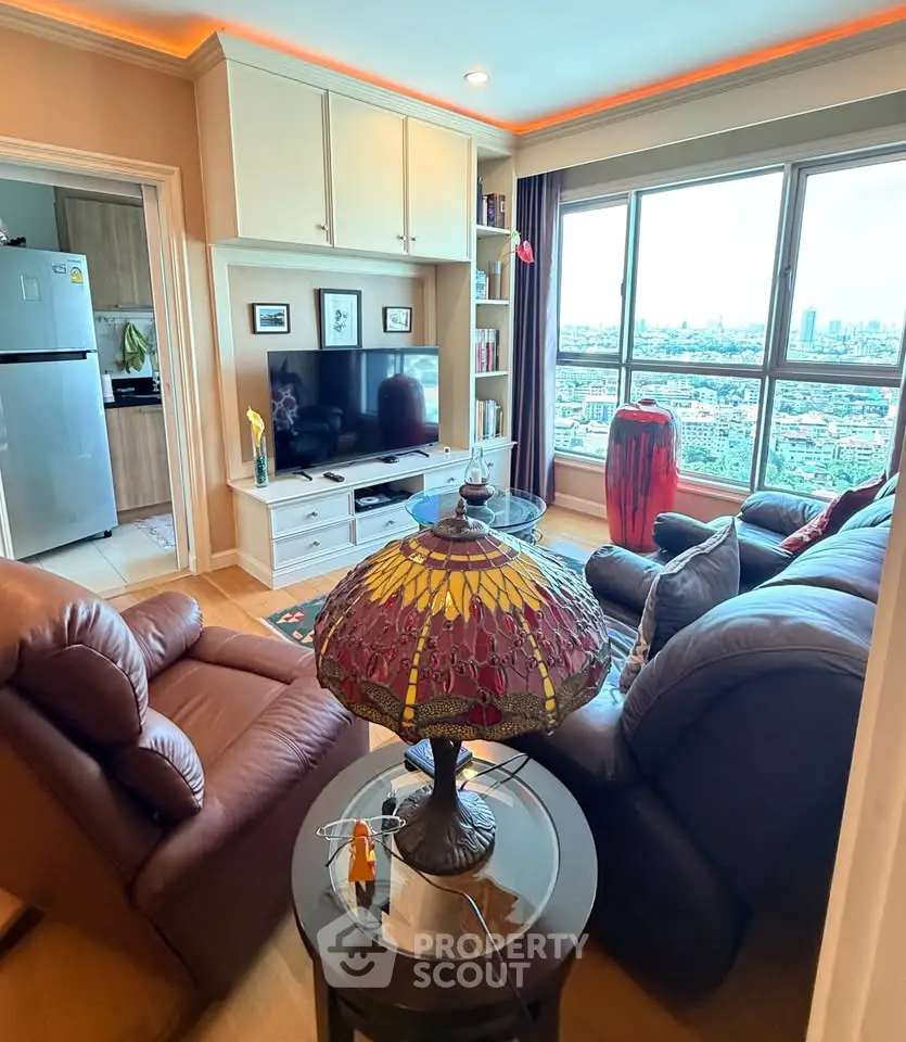Cozy living room with city view, leather seating, and stained glass lamp in modern apartment.