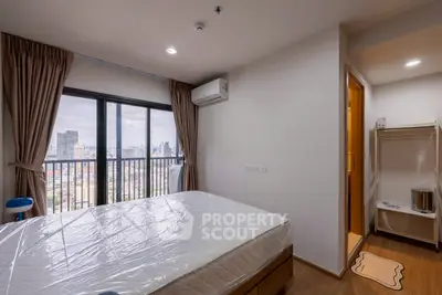 Modern bedroom with city view, featuring a large window and air conditioning, perfect for urban living.