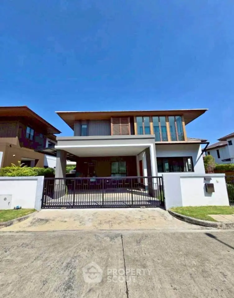 Modern two-story house with spacious driveway and contemporary design.