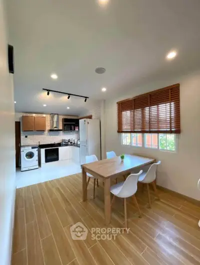Modern kitchen and dining area with wooden flooring and natural light.