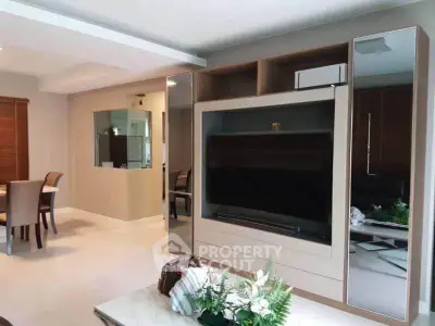 Modern living room with sleek entertainment center and dining area, perfect for stylish urban living.
