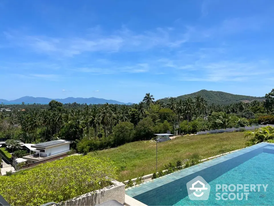 Stunning infinity pool with panoramic mountain and lush greenery views in tropical paradise.