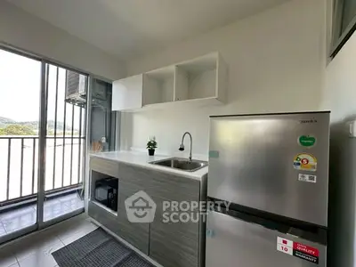 Modern kitchen with sleek cabinetry and stainless steel fridge, offering a bright and airy atmosphere.