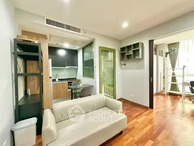 Modern living room with open kitchen and hardwood floors in stylish apartment