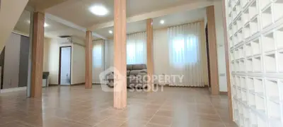 Spacious living room with modern design and ample natural light, featuring elegant columns and tiled flooring.