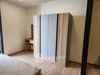 Modern bedroom with wooden wardrobe and desk, showcasing minimalist design.