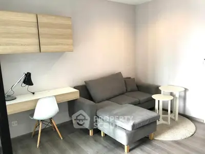 Modern living room with cozy gray sofa, stylish desk, and chic decor