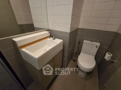 Modern bathroom with sleek sink and toilet in a compact space.