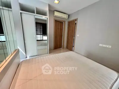 Modern bedroom with built-in wardrobe and air conditioning in a stylish apartment.