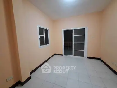 Spacious empty room with tiled floor and sliding glass door