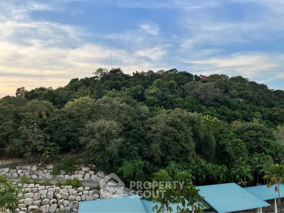 Scenic view of lush greenery and rooftops under a vibrant sky, perfect for nature lovers.