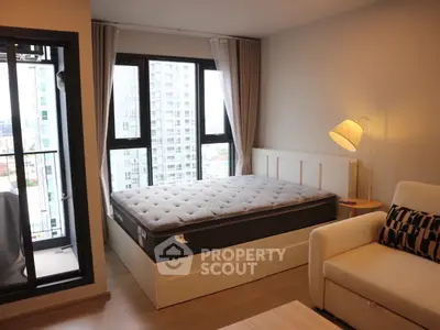 Modern bedroom with city view, featuring cozy bed and stylish decor.