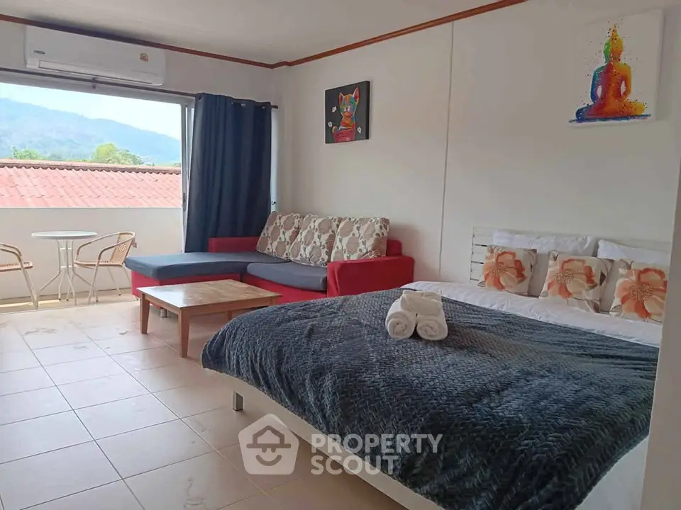Cozy studio with mountain view, modern decor, and balcony access.