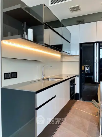 Modern kitchen with sleek cabinetry and integrated appliances in a stylish apartment.