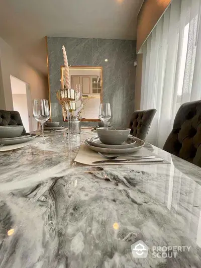 Luxurious dining room with elegant marble table and plush chairs, perfect for sophisticated gatherings.