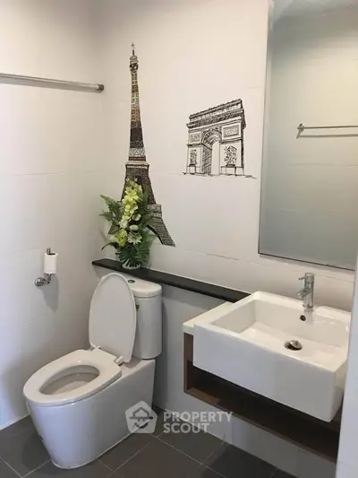 Modern bathroom with stylish Paris-themed wall art and sleek fixtures.