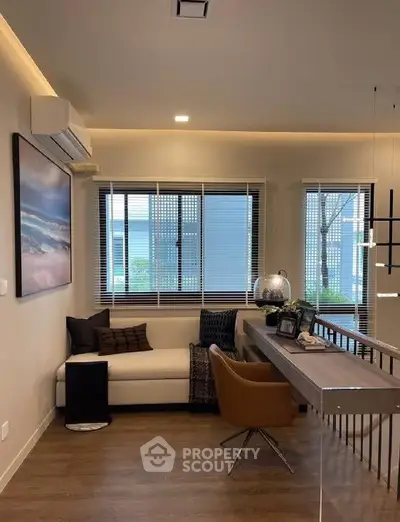 Modern living room with stylish decor and large windows offering natural light.