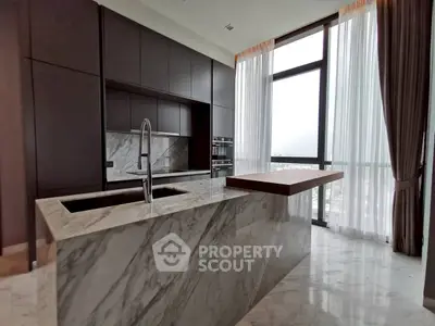 Luxurious modern kitchen with marble countertops and floor-to-ceiling windows