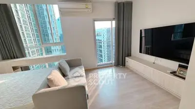 Modern living room with large TV and balcony view in high-rise apartment