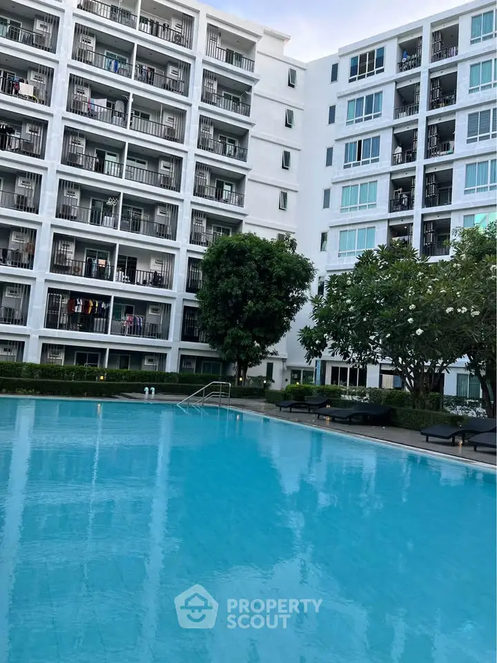 Modern apartment complex with a stunning pool and lush greenery, perfect for luxury living.