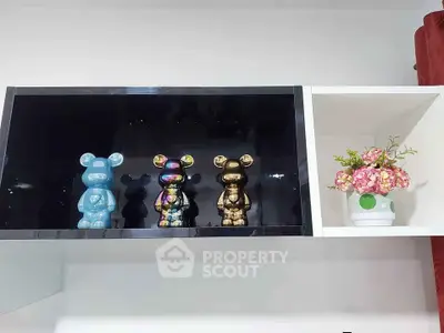 Modern shelf with decorative bear figurines and floral arrangement, perfect for stylish living room decor.
