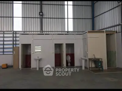 Industrial warehouse bathroom with multiple stalls and sinks