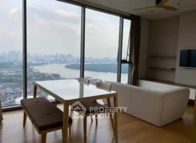 Stunning living room with panoramic city and river views, featuring modern furniture and floor-to-ceiling windows.