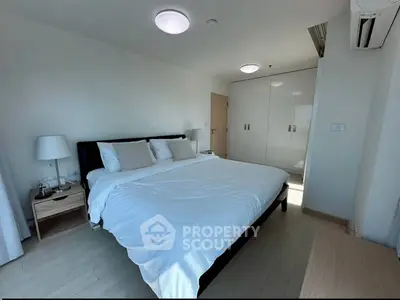 Spacious bedroom with modern furnishings and ample natural light