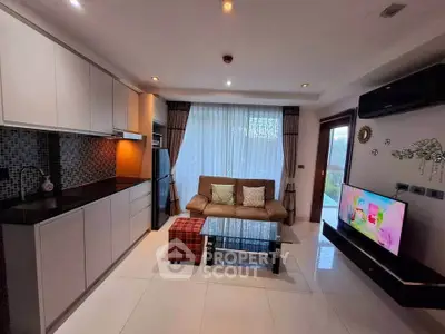 Modern living room with open kitchen, stylish decor, and large window for natural light.