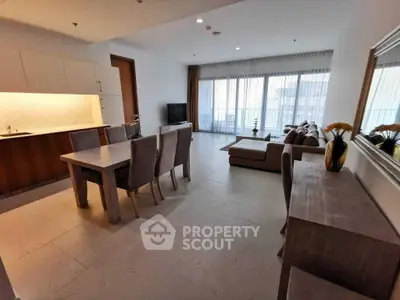 Spacious open-plan living and dining area with modern furnishings and large windows.