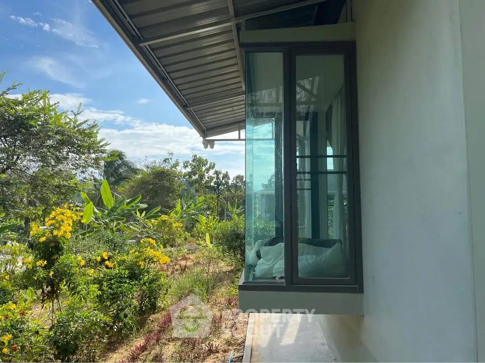 Modern home with large windows and lush garden view