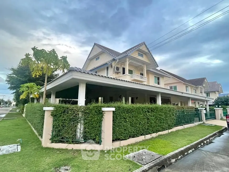 Charming two-story house with lush green hedge and spacious corner lot