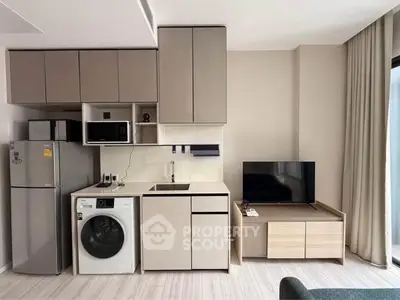 Modern compact kitchen with integrated appliances and sleek cabinetry in a stylish apartment.