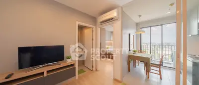 Modern apartment interior with open layout, featuring a cozy living area, dining space, and balcony with city view.